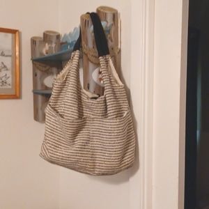 A travel bag that is cream and black colored with a hit of glitter